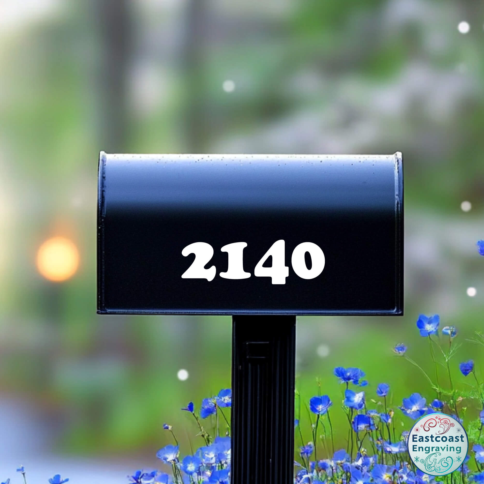 Black mailbox with bold white vinyl numbers “2140” and blue wildflowers in the background