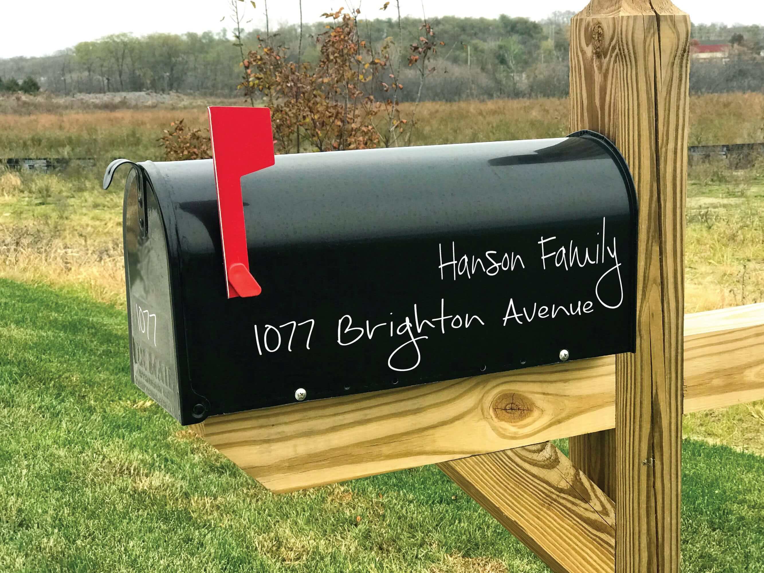 Black mailbox with vinyl address decal featuring family name and number