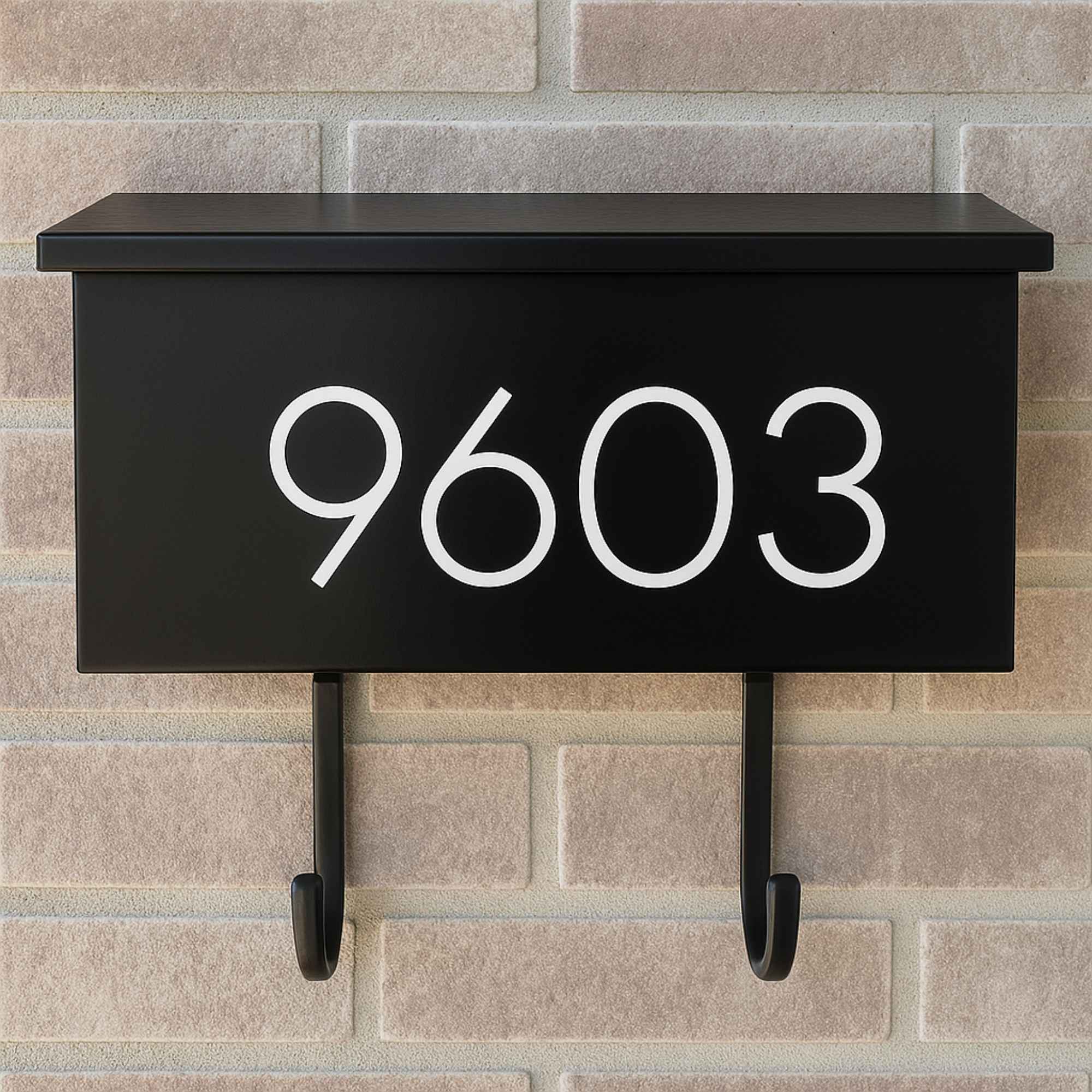 Vinyl mailbox number decal on a black wall-mounted mailbox in modern sans serif font