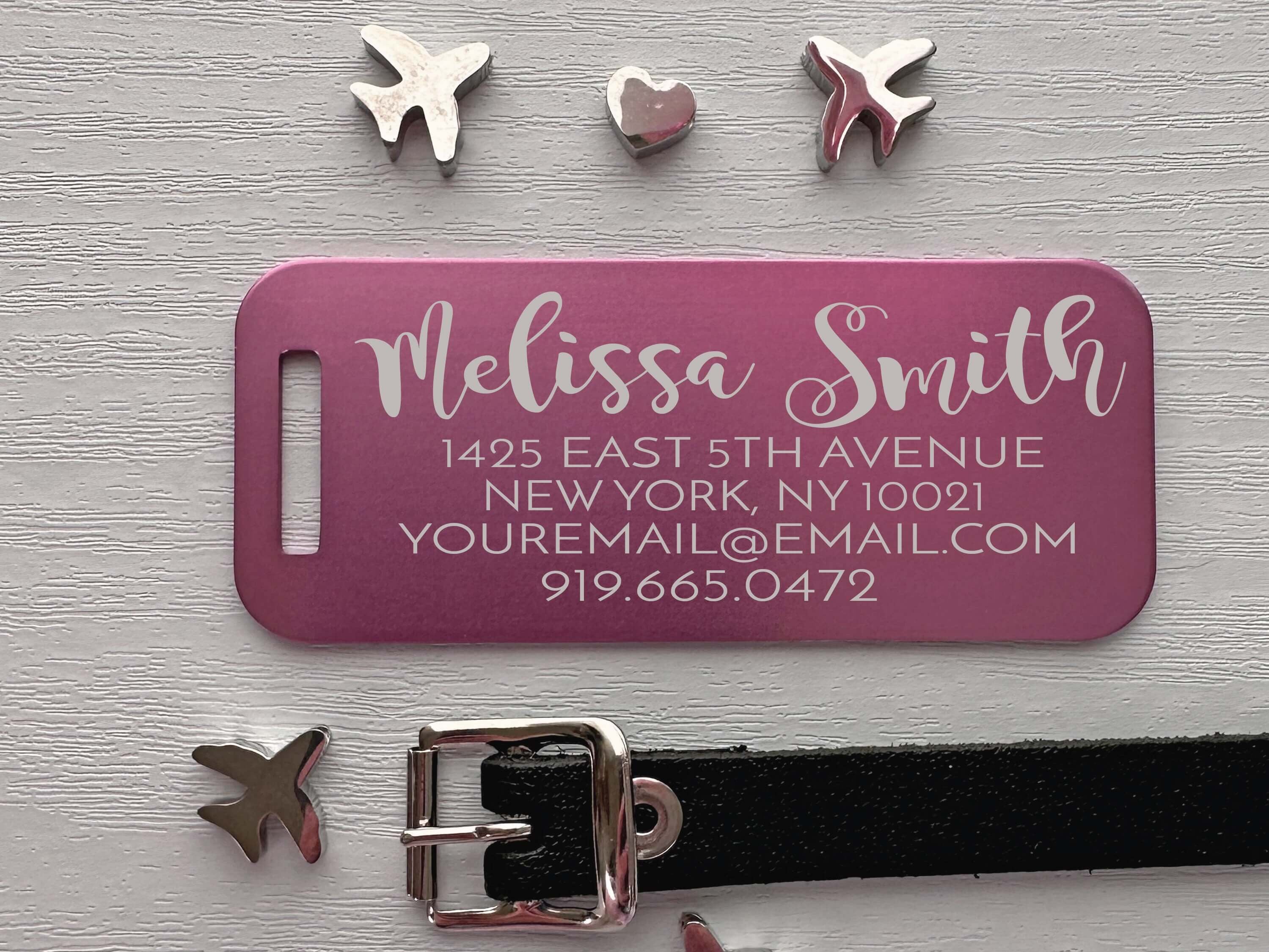 Pink metal luggage ID tag with engraved travel nameplate and durable strap