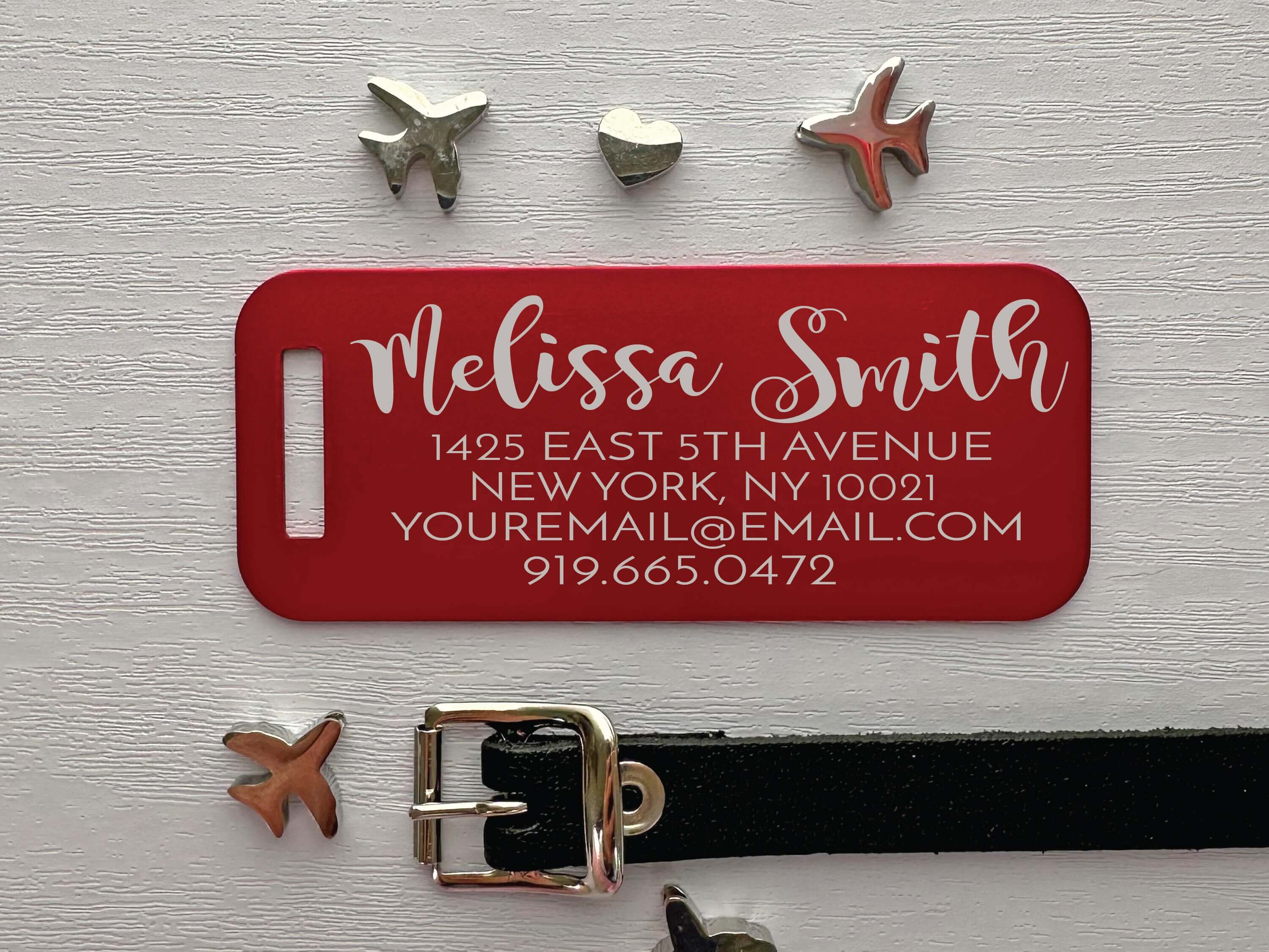 Red custom metal travel tag with engraved contact info and nameplate design