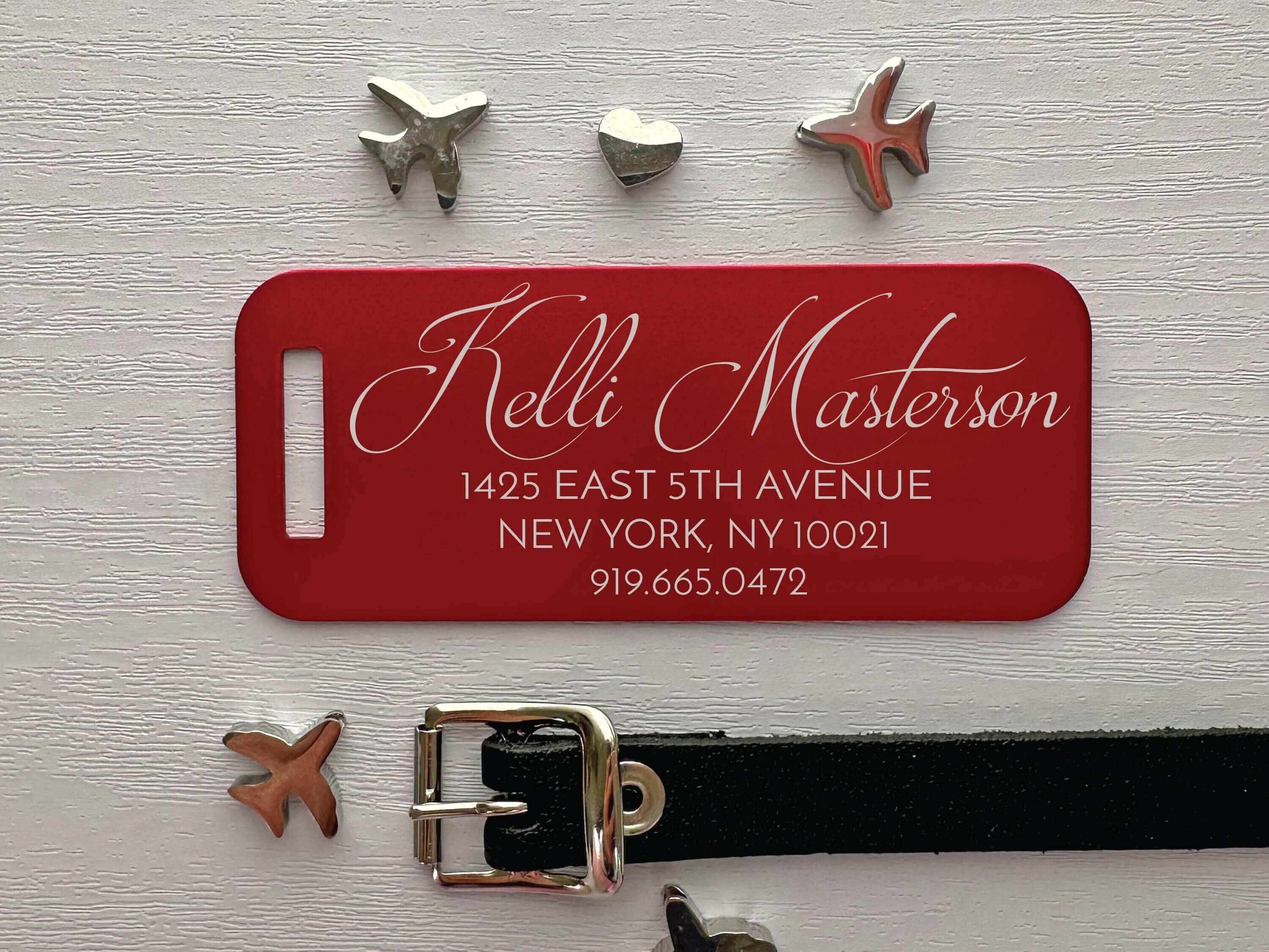 Red luggage tag featuring custom script name and durable aluminum finish