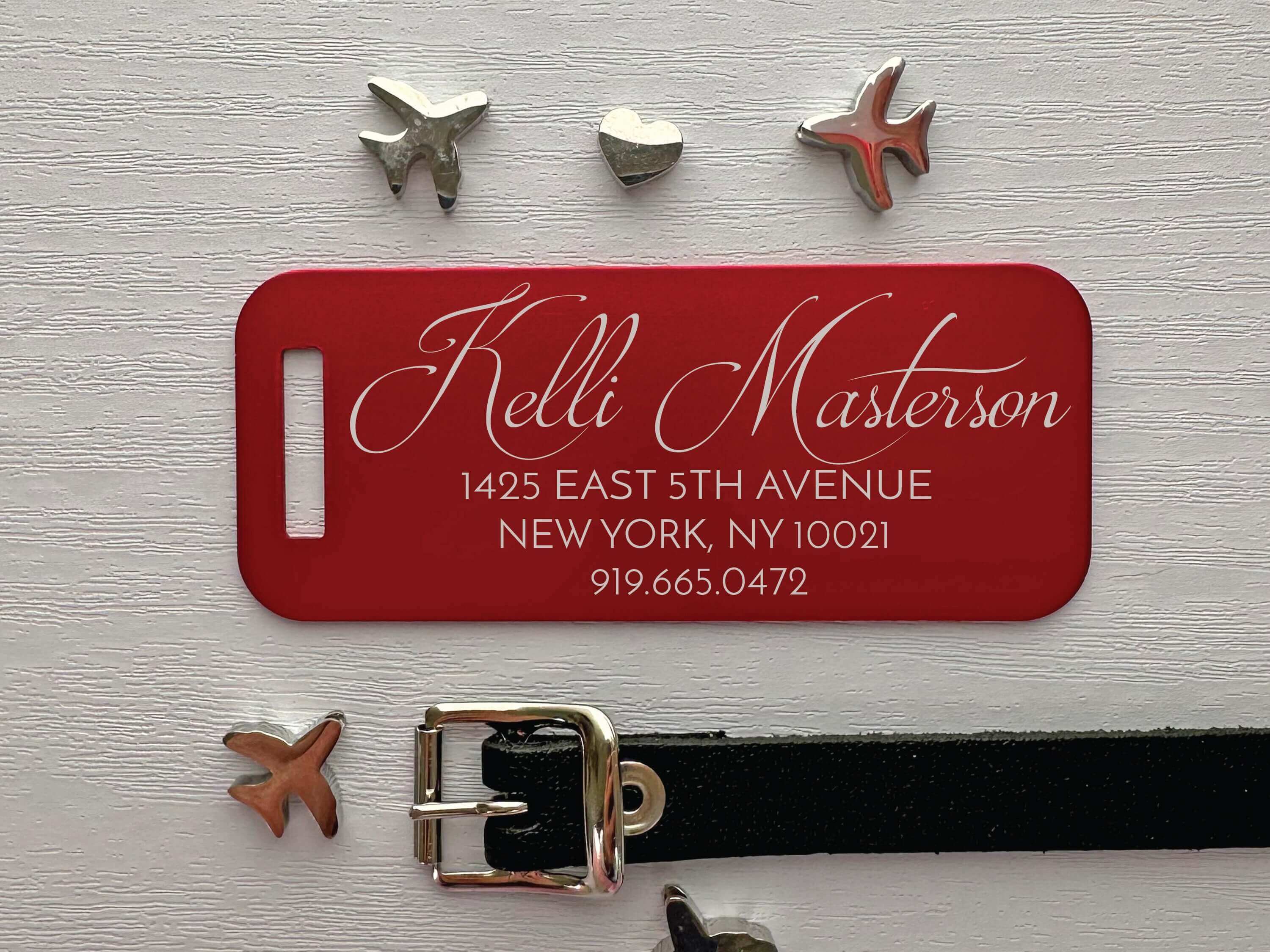 Red luggage tag featuring custom script name and durable aluminum finish