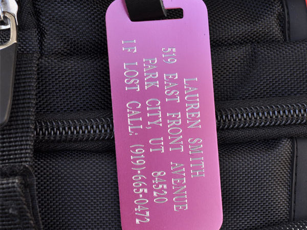 Custom pink aluminum luggage tag with engraved contact info and leather strap for backpacks, suitcases, and kids’ bags