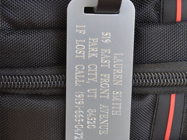 Custom engraved silver luggage tag with black leather strap for personalized bag identification, ideal for air travel, work gear, and secure ID.