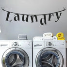 Clothesline laundry room wall decal with whimsical hanging-letter design